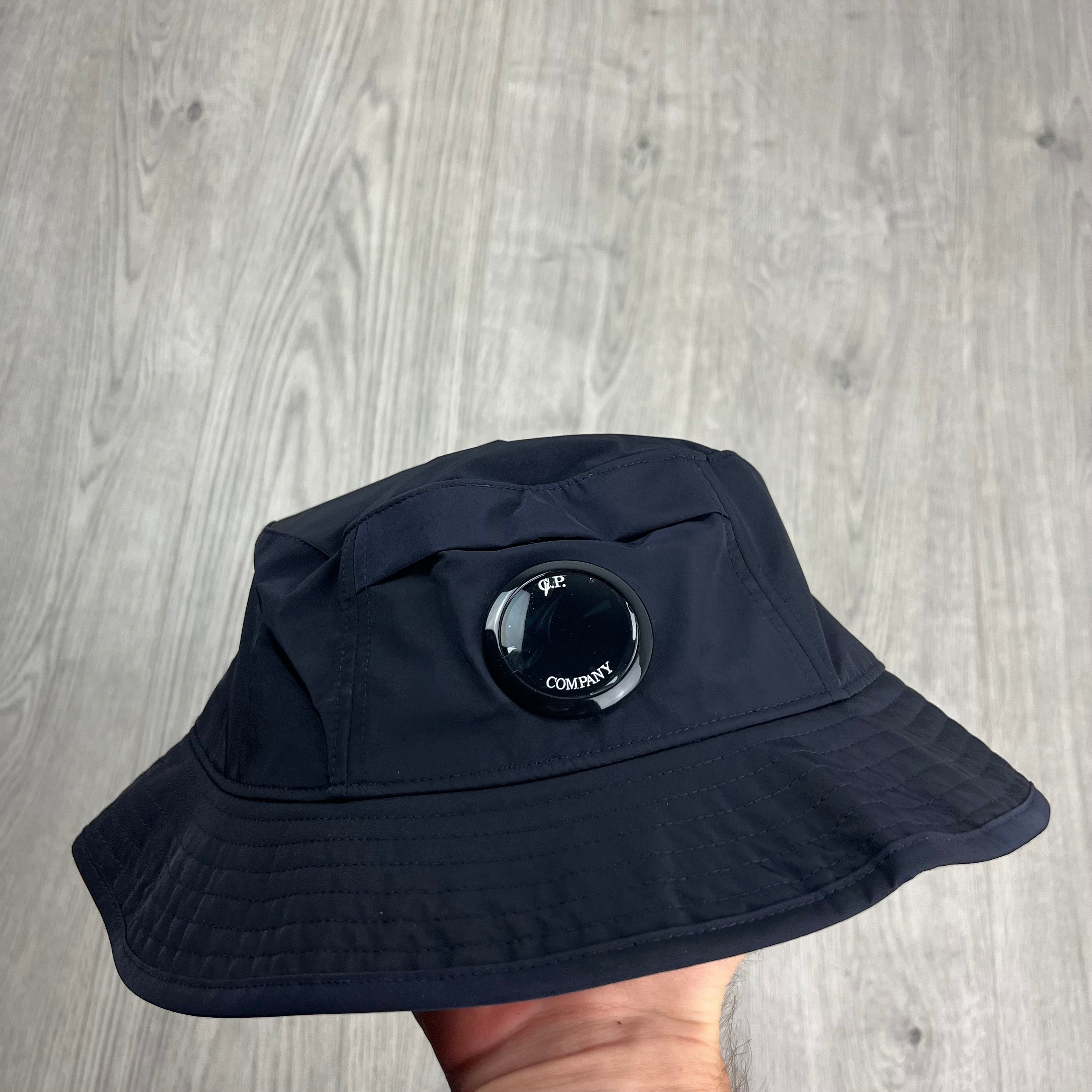 CP Company Lens Bucket Hat in Total Eclipse Navy Blue. On sale at Open Attire.